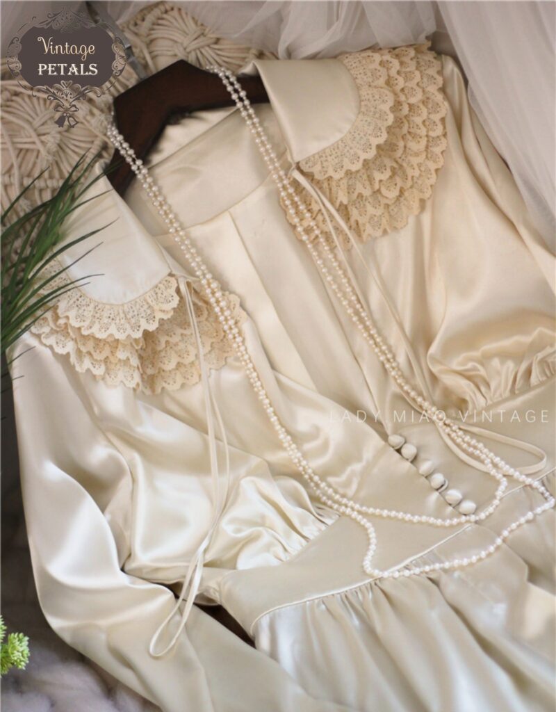Váy trắng cổ điển xẻ ngực sâu phối chuỗi hạt